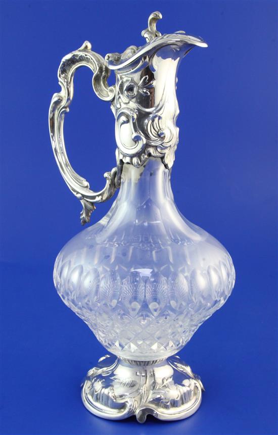 A modern Rococco style sterling silver mounted glass claret jug, 11.5in.